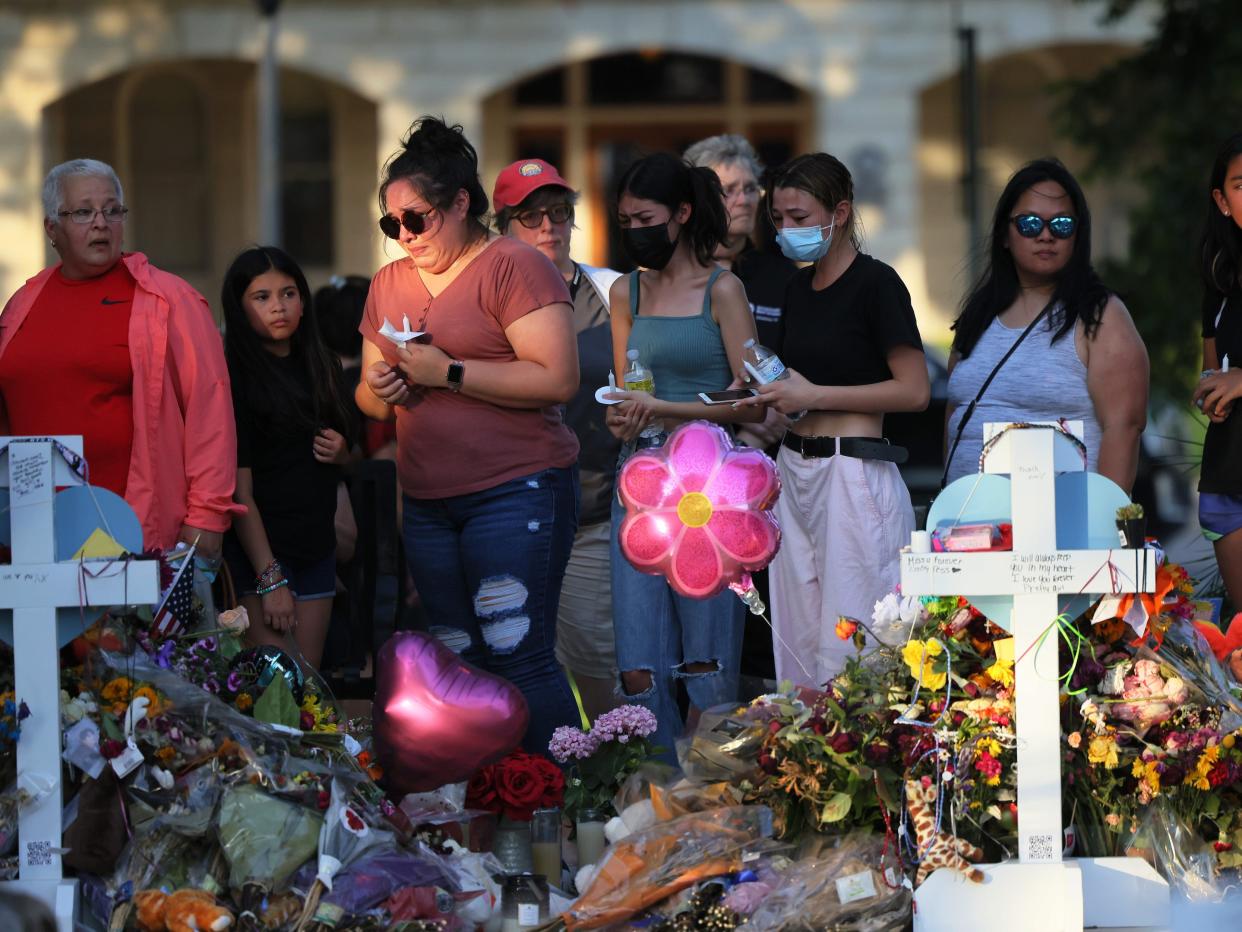 People visit a memorial for the victims of the Robb Elementary School mass shooting at the City of Uvalde Town Square on May 29, 2022 in Uvalde, Texas. 19 children and two adults were killed on May 24th during a mass shooting at Robb Elementary School after man entered the school through an unlocked door and barricaded himself in a classroom where the victims were located.