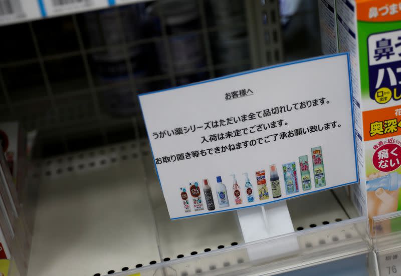 A sign notifying sold-out of gargling medicines is displayed at an empty shelves at a drugstore in Tokyo