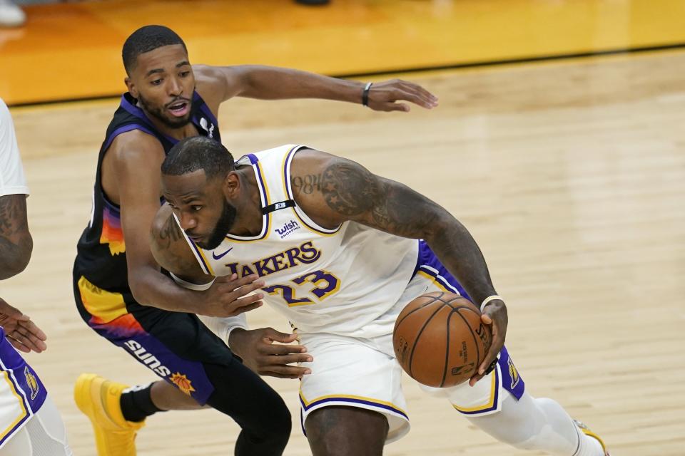 Los Angeles Lakers forward LeBron James (23) drives past Phoenix Suns forward Mikal Bridges, left, during the first half of Game 1 of an NBA basketball first-round playoff series Sunday, May 23, 2021, in Phoenix. (AP Photo/Ross D. Franklin)