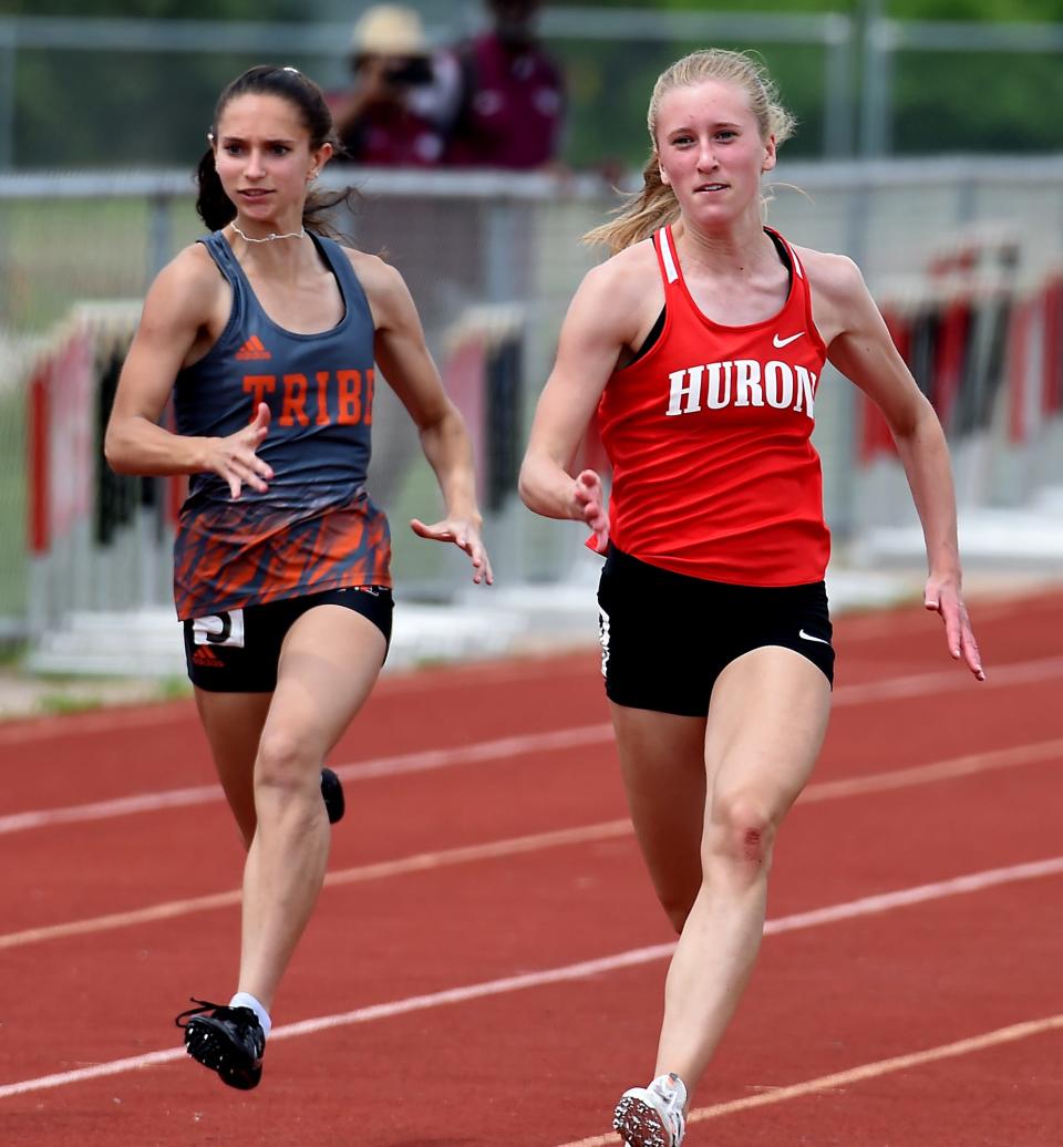 Elizabeth Anderson of Huron wins the 100m beating Dakota Schlorf of Tecumseh who placed third at the D2 Regional held at Milan Friday, May 20, 2022.