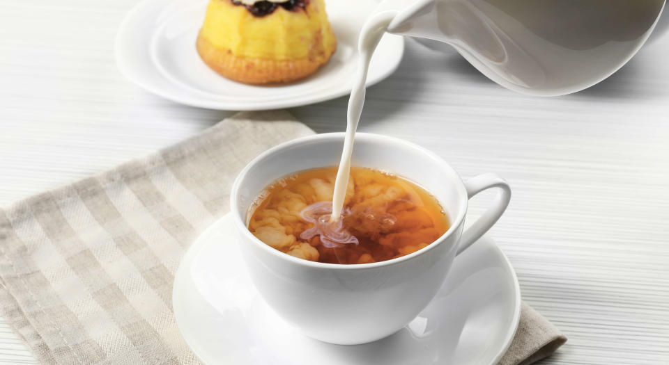 Milk being poured in to a cup of tea