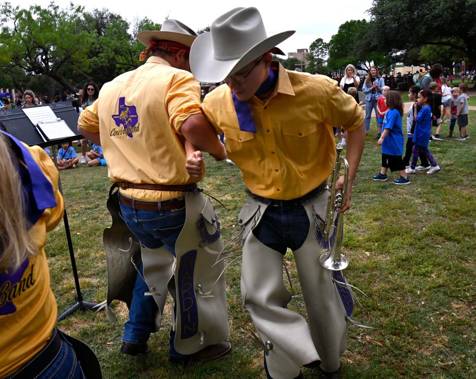 Cowboy Band trumpeters Jarett Daniel (left) and Tim Baek lock arms and spin during a pause in their part of the band’s performance during Western Heritage Day at Hardin-Simmons University April 25.