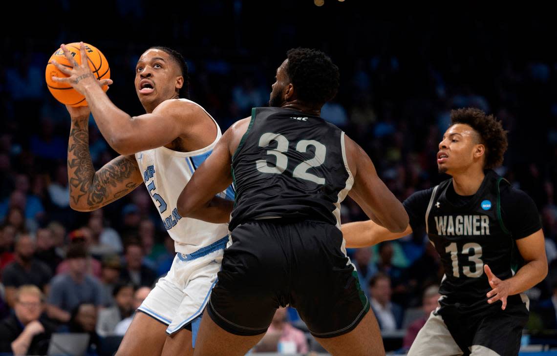 North Carolina’s Armando Bacot (5) works his way to the basket against Wagner’s Keyontae Lewis (32) and Julian Brown (13) in the first half on Thursday, March 21, 2024 during the NCAA Tournament at Spectrum Center in Charlotte, N.C.