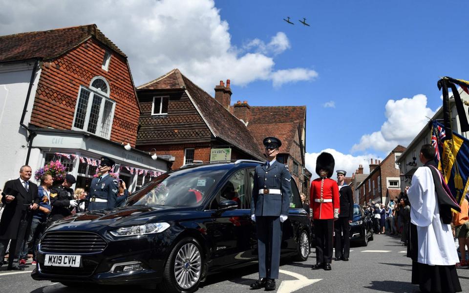 Two spitfires perform a flypast over the village of Ditchling - AFP