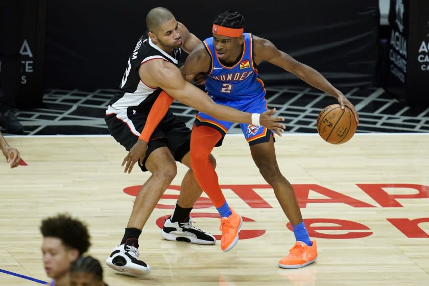 Los Angeles Clippers forward Nicolas Batum, left, defends against Oklahoma City Thunder guard.