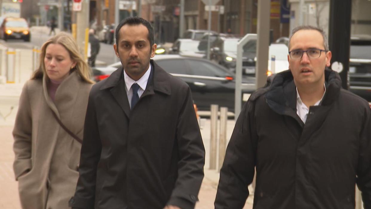 Umar Zameer, left, with his defence lawyer Nader Hasan, walking into court in downtown Toronto on April 2. Zameer is accused of killing Det.-Const. Jeffrey Northrup nearly three years ago. An officer testified on Friday that Zameer appeared shocked and 'not completely present' after his arrest. (Paul Smith/CBC - image credit)
