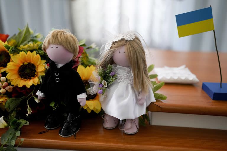 Muñecos que representan a los novios decoran una mesa en una oficina de registro civil en Kiev