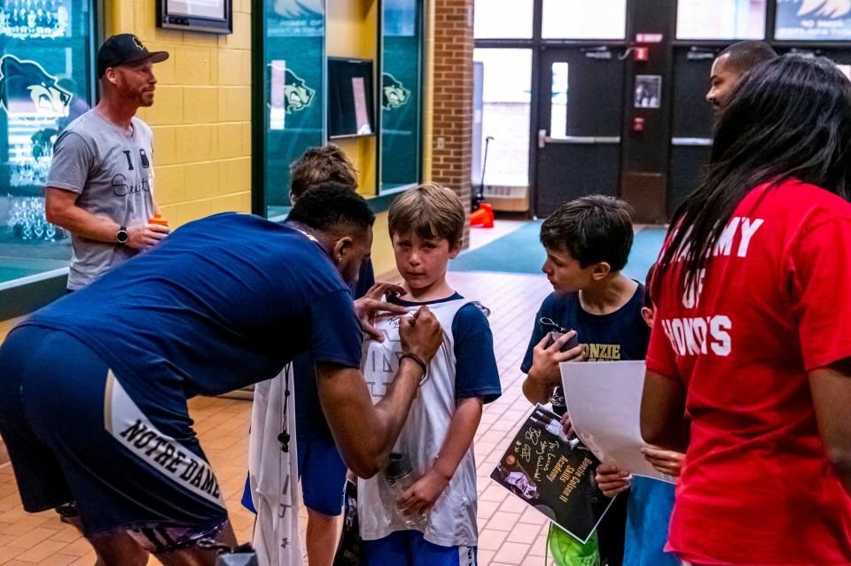 Bonzie Colson II signs shirts for partipants of his Skills Academy.