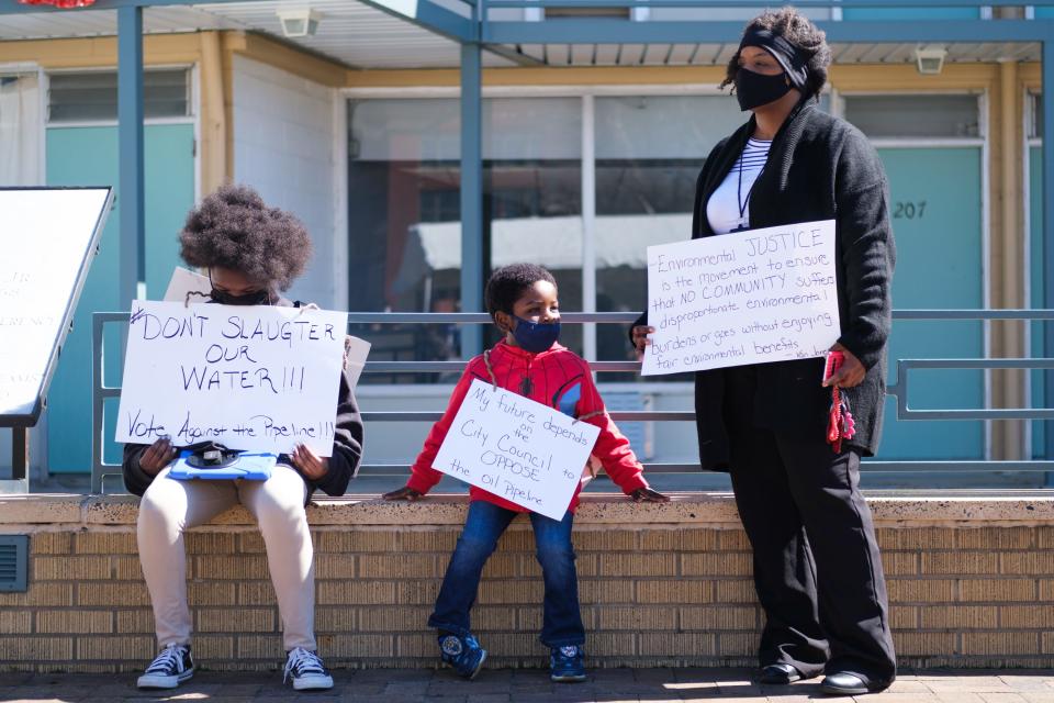 Kizzy Jones, a co-founder of Memphis Community Against the Pipeline (MCAP), holds signs outside the National Civil Rights Museum with her family during a rally against the construction of the Byhalia Connection Pipeline on Tuesday, Feb. 23, 2021, in Memphis, Tenn.
