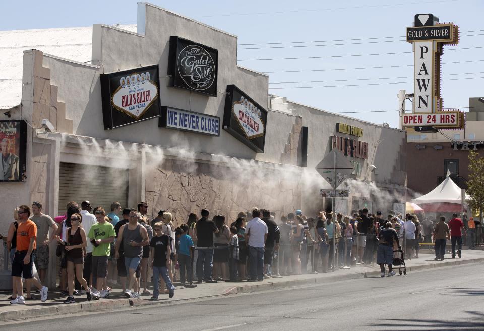 Customers wait in a line that stretches down the block to enter the Gold and Silver Pawn Shop, Wednesday, April 3, 2013, in Las Vegas. Pawn sales at the shop, which is featured in the television reality show Pawn Stars, bring in about $20 million a year, up from the $4 million a year it made before the show aired. Turning small business owners into stars has become a winning formula for television producers, but the businesses featured in the shows are cashing in, too. Sales explode after just a few episodes have aired, transforming nearly unknown small businesses into household names. (AP Photo/Julie Jacobson)