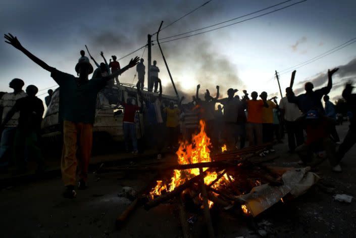 Manifestantes alrededor de una hoguera.