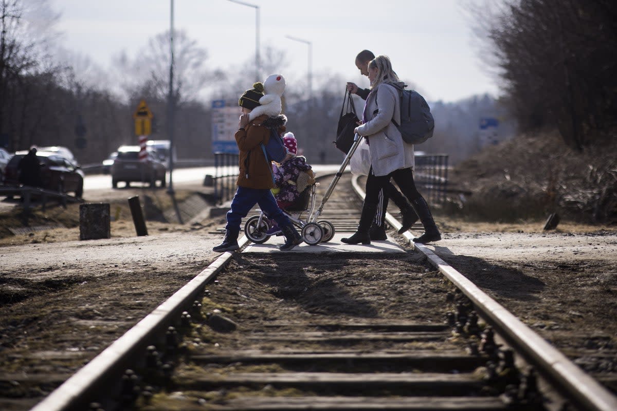 Ukraine refugees cross over the railway tracks at the Krościenko border crossing point on the Poland/Ukraine border (Toby Madden/DEC/PA) (PA Media)