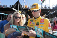 Kyle Busch signs autographs as he enters the garage for a NASCAR Cup Series auto race practice at Homestead-Miami Speedway in Homestead, Fla., Saturday, Nov. 16, 2019. (AP Photo/Luis M. Alvarez)