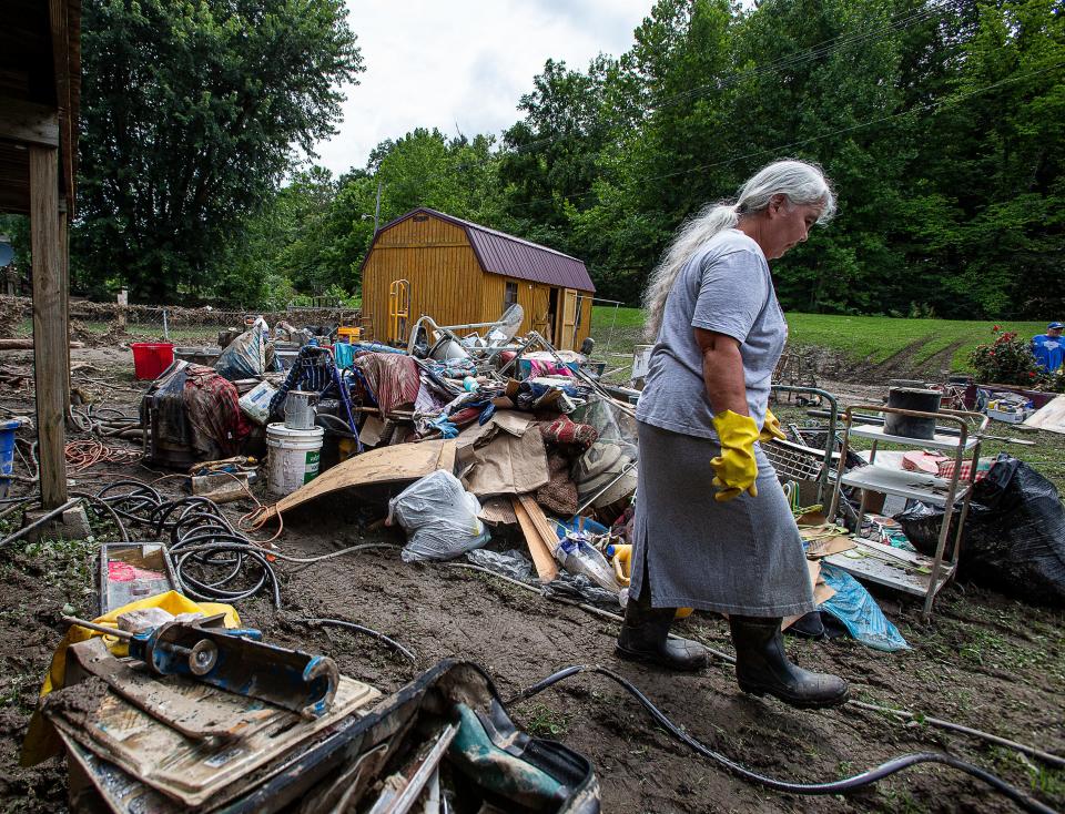 Libby Duty, 64, of Jenkins, Kentucky walked through her back yard while clearing out her basement on Saturday July 30, 2022, after historic rains flooded many areas of Eastern Kentucky. 