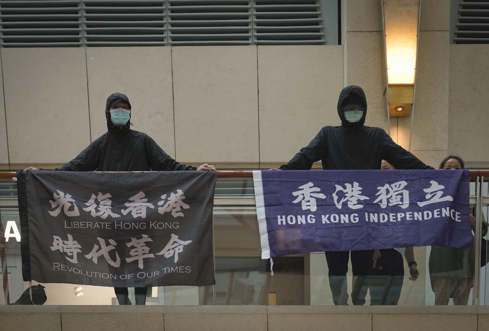 FILE - Protesters show a banner "Librate Hong Kong, Revolution of out time," left, and "Hong Kong Independence" in a shopping mall during a protest in Hong Kong, on June 9, 2020. Criticizing laws or chanting anti-government slogans can be enough to jail someone for sedition in Hong Kong, an appeal court ruled Thursday, March 7, 2024 in a landmark case under a colonial-era law increasingly used to crush dissent. (AP Photo/Vincent Yu, File)