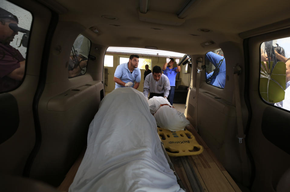 The bodies of El Salvadoran migrant Oscar Alberto Martinez Ramírez, 25, and his nearly two-year-old daughter Valeria, are placed into a funeral home van at the morgue in Matamoros, Tamaulipas state, Mexico, Wednesday, June 26, 2019. The pair drowned while trying to cross the Rio Grande to Brownsville, Texas. Martinez's wife Tania Vanessa Avalos, 21, survived. (AP Photo/Rebecca Blackwell)