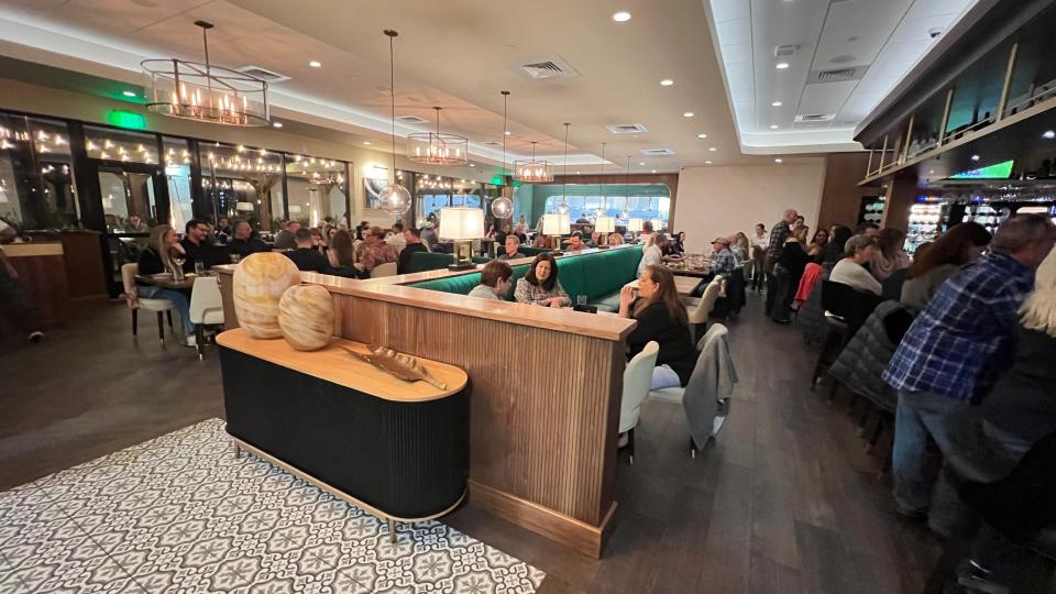 Palm City Social is gorgeous. Emerald green booths, cream upholstered chairs, blonde wood, brass and glass chandeliers, and a considerably sized square bar deliver the atmosphere for fun and socializing.