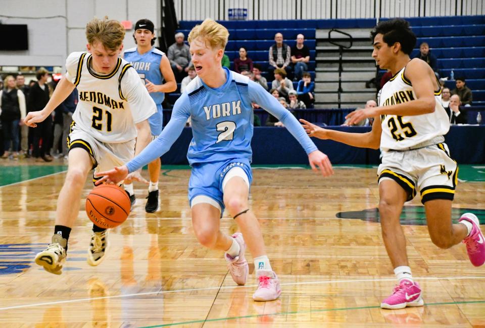York’s Derek Parsons, center, tries to maintain control of the ball as he is defended by Medomak Valley’s Jaiden Starr, left, and Vishal Mellor.