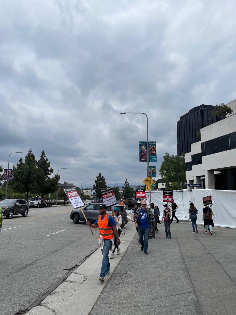 WGA protestors crossing Bob Hope Ave. at Lankershim Blvd. on June 6. The sidewalk behind them has been fenced off.