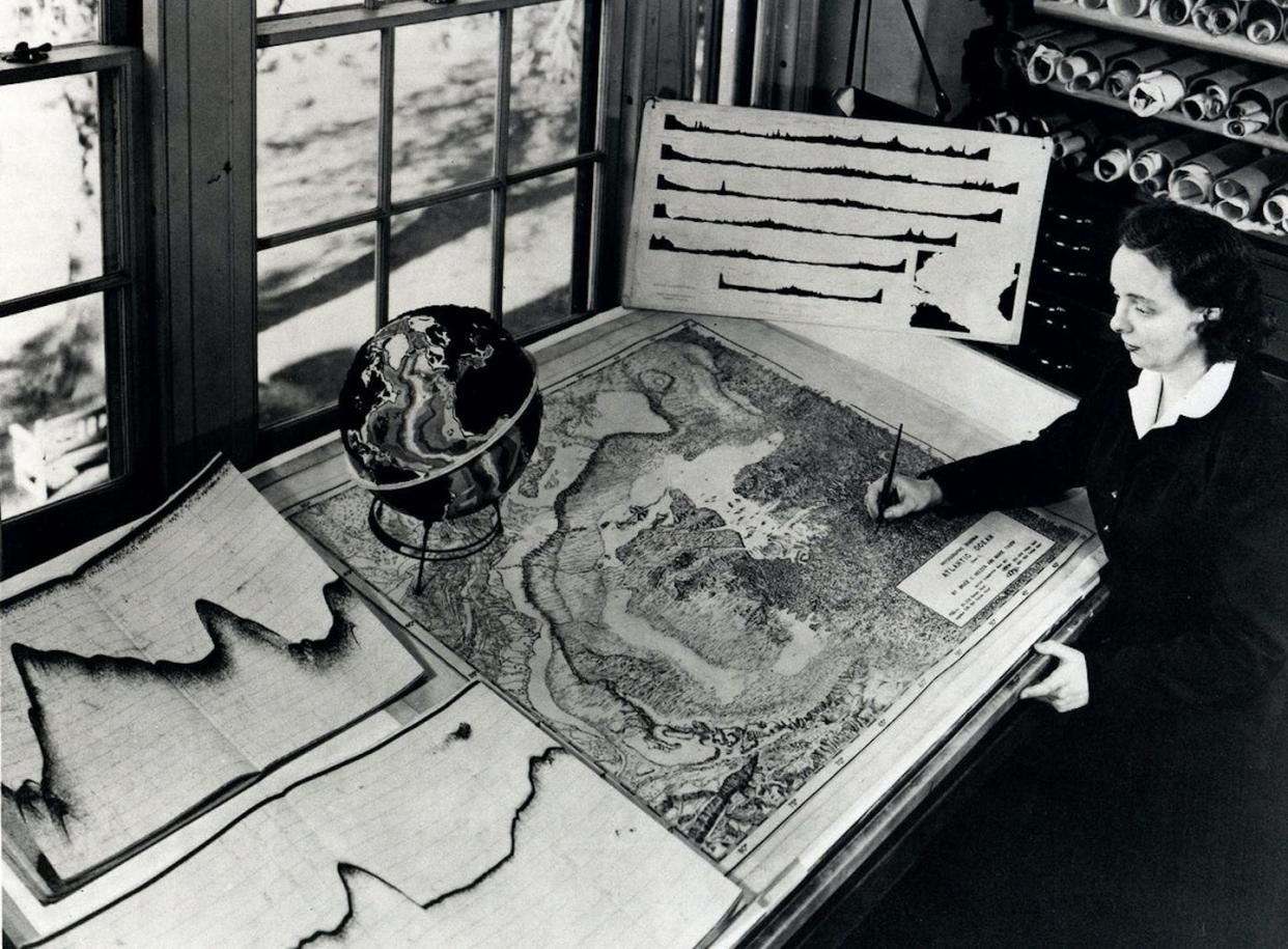 Tharp with an undersea map at her desk. Rolled sonar profiles of the ocean floor are on the shelf behind her. <a href="https://www.ldeo.columbia.edu/news-events/join-us-celebrating-marietharp100" rel="nofollow noopener" target="_blank" data-ylk="slk:Lamont-Doherty Earth Observatory and the estate of Marie Tharp;elm:context_link;itc:0;sec:content-canvas" class="link ">Lamont-Doherty Earth Observatory and the estate of Marie Tharp</a>