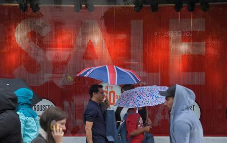 FILE PHOTO: Shoppers walk past a sale sign in central London, Britain June 27, 2017. REUTERS/Toby Melville/File Photo