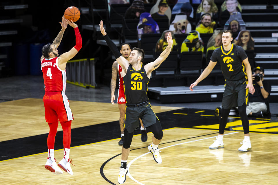 Ohio State guard Duane Washington Jr. (4) makes a three-point basket as Iowa's Connor McCaffery (30) defends in the second half during an NCAA college basketball game Thursday, Feb. 4, 2021, in Iowa City, Iowa. (Joseph Cress/Iowa City Press-Citizen via AP)