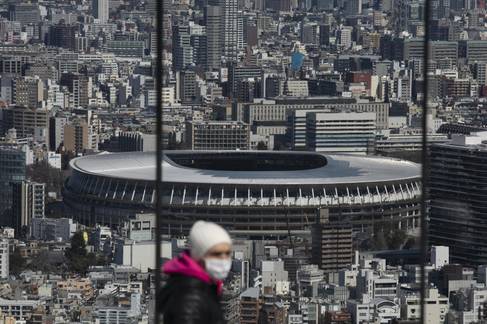 In this March 3, 2020, photo, the New National Stadium, a venue for the opening and closing ceremonies at the Tokyo 2020 Olympics, is seen from Shibuya Sky observation deck in Tokyo. Japan's Olympic minister has suggested in Parliament that the Tokyo Olympics might be pushed back a few months from it July 24 opening. The games are under threat from a spreading virus from China that has reached the pandemic stage. But the so-called “Home City Contract”signed by the International Olympic Committee and Japanese officials gives the IOC wide latitude in terminating the Olympics. (AP Photo/Jae C. Hong)