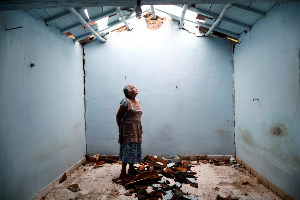 <p>Tomasa Mozo, 69, a housewife, looks up at the roof as she poses for a portrait inside the ruins of her house after an earthquake in San Jose Platanar, at the epicentre zone, Mexico, September 28, 2017. The house was badly damaged but with the help of her family Mozo rescued some furniture. She lives in another room of her house and hopes to repair the damage as soon as possible. “I’m afraid to go out, I can not sleep,” Mozo said. (Photo: Edgard Garrido/Reuters) </p>