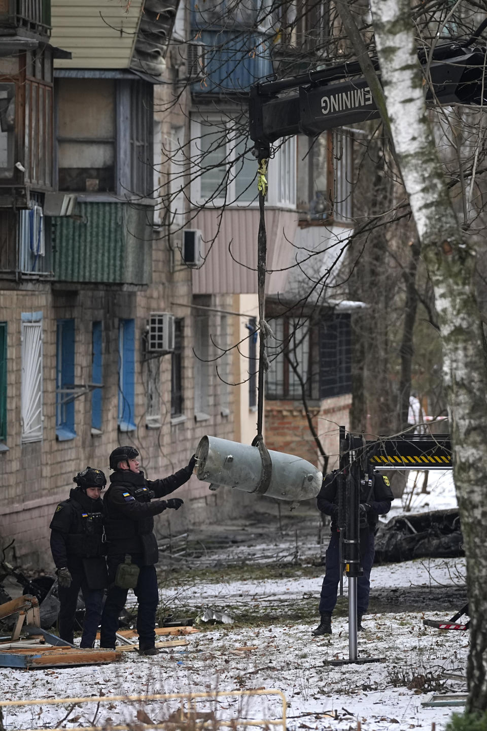 Sappers load an unexploded missile warhead onto a truck at the site of Russian attack in Kyiv, Ukraine, Tuesday, Jan. 23, 2024. (AP Photo/Efrem Lukatsky)