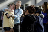 D.J. Hamburger, center in blue, a teacher at Saugus High School comforts a student after reports of a shooting at the school on Thursday, Nov. 14, 2019, in Santa Clarita, Calif. (AP Photo/Marcio Jose Sanchez)