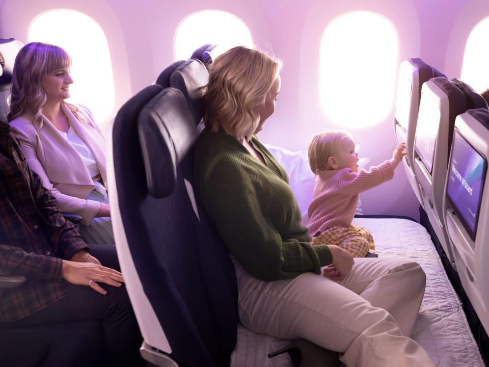 A mother an baby relax on an air New Zealand Skycoach