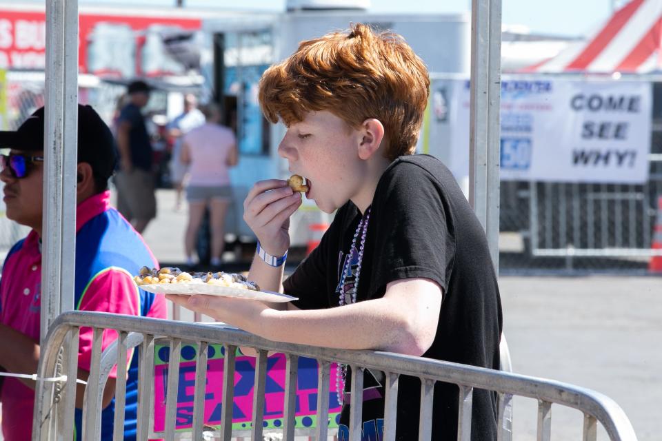 Dustin Hammes (13) of Rockport enjoys a funnel cake as his friends ride a carnival ride at the 44th Annual Fulton Oysterfest Saturday, Mar. 4, 2023.