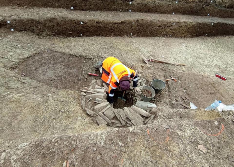 Archaeologists excavate a well.