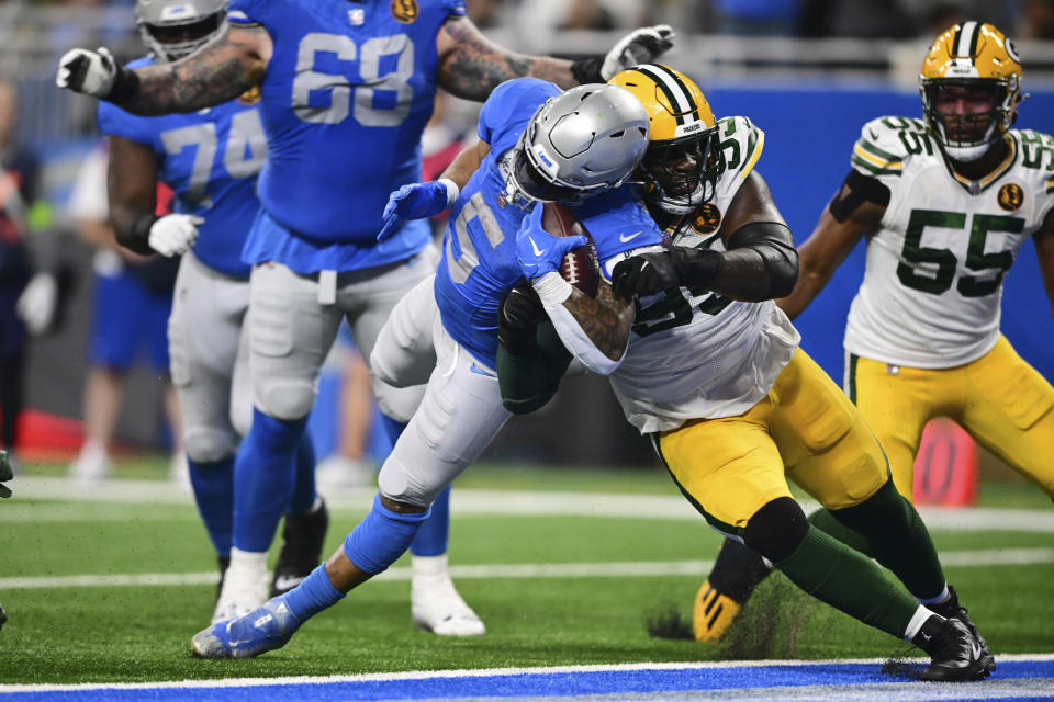 Detroit Lions running back David Montgomery gets by Green Bay Packers defensive tackle Devonte Wyatt (95) for a two-point conversion during the second half of an NFL football game, Thursday, Nov. 23, 2023, in Detroit. (AP Photo/David Dermer)