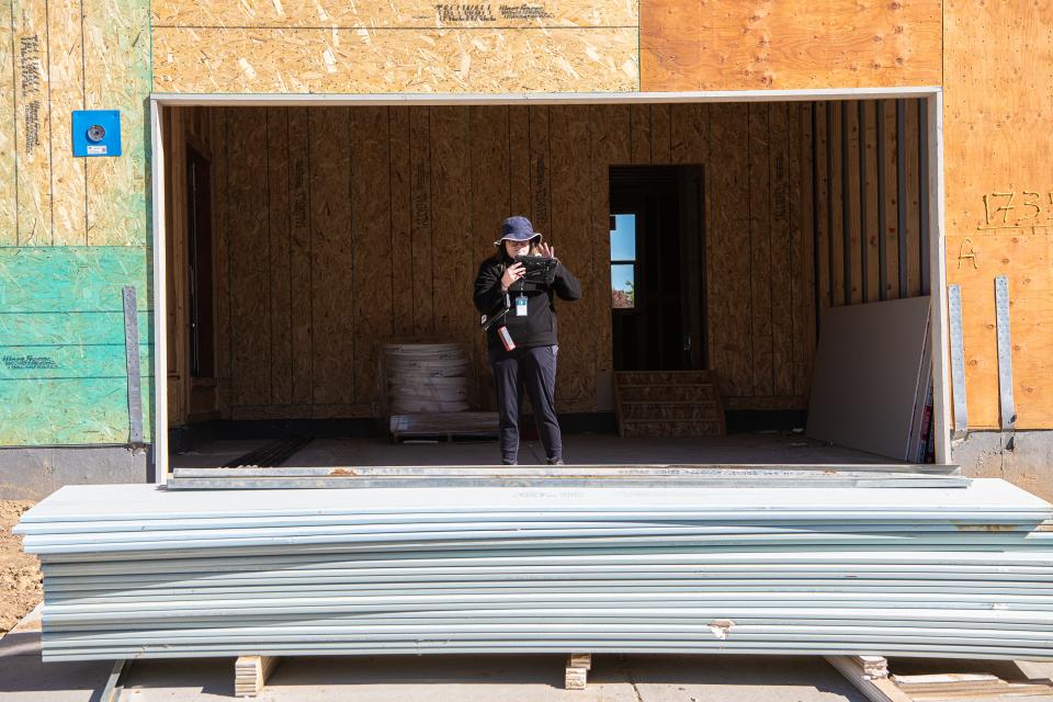 Stevie Townsend, data collector with the Larimer County Assessor's Office, takes notes as she collects exterior measurements of a new residential building under construction in the Hansen Farm subdivision on Monday in Fort Collins.