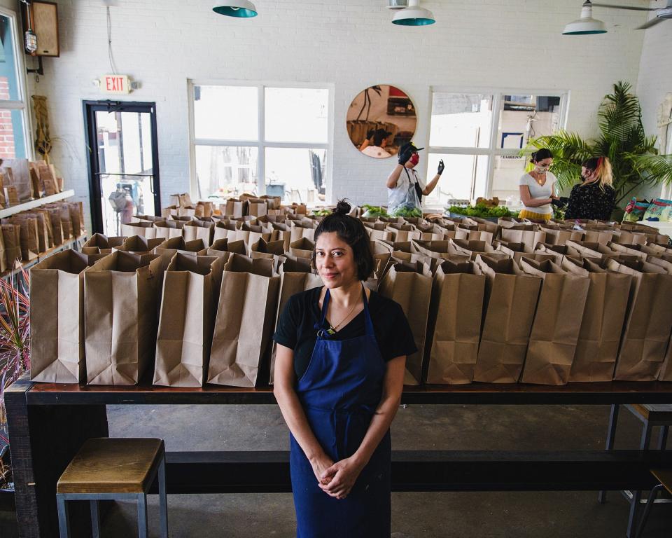 Maricela Vega stands among CSA bags being prepared for customer pickup in the dining room of 8Arm.