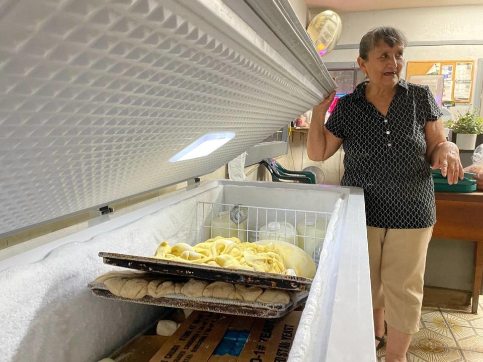 Estela Villagómez abre uno de los nuevos congeladores que su familia tuvo que comprar para su negocio, El Gallito Bakery, en Planada, California, el 6 de julio de 2023. El negocio familiar perdió miles de dólares en equipos e ingredientes de panadería en la inundación de enero.