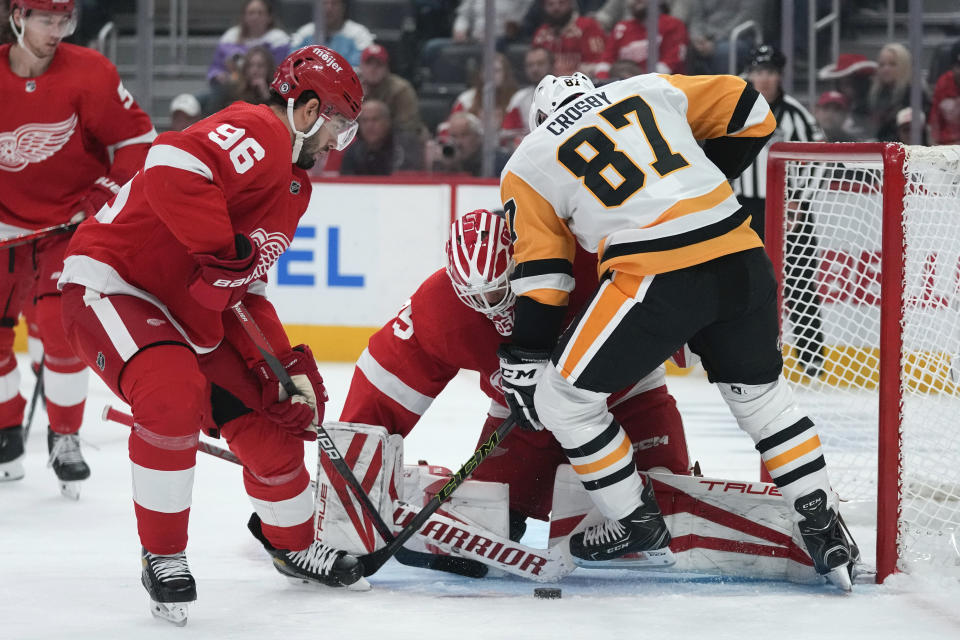 Detroit Red Wings goaltender Ville Husso (35) stops a Pittsburgh Penguins center Sidney Crosby (87) shot as defenseman Jake Walman (96) defends in the first period of an NHL hockey game Wednesday, Oct. 18, 2023, in Detroit. (AP Photo/Paul Sancya)