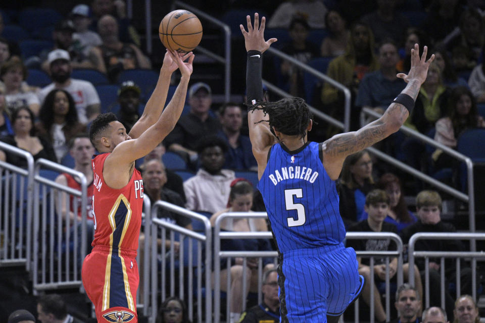 New Orleans Pelicans guard CJ McCollum (3) shoots as Orlando Magic forward Paolo Banchero (5) defends during the first half of an NBA basketball game Friday, Jan. 20, 2023, in Orlando, Fla. (AP Photo/Phelan M. Ebenhack)