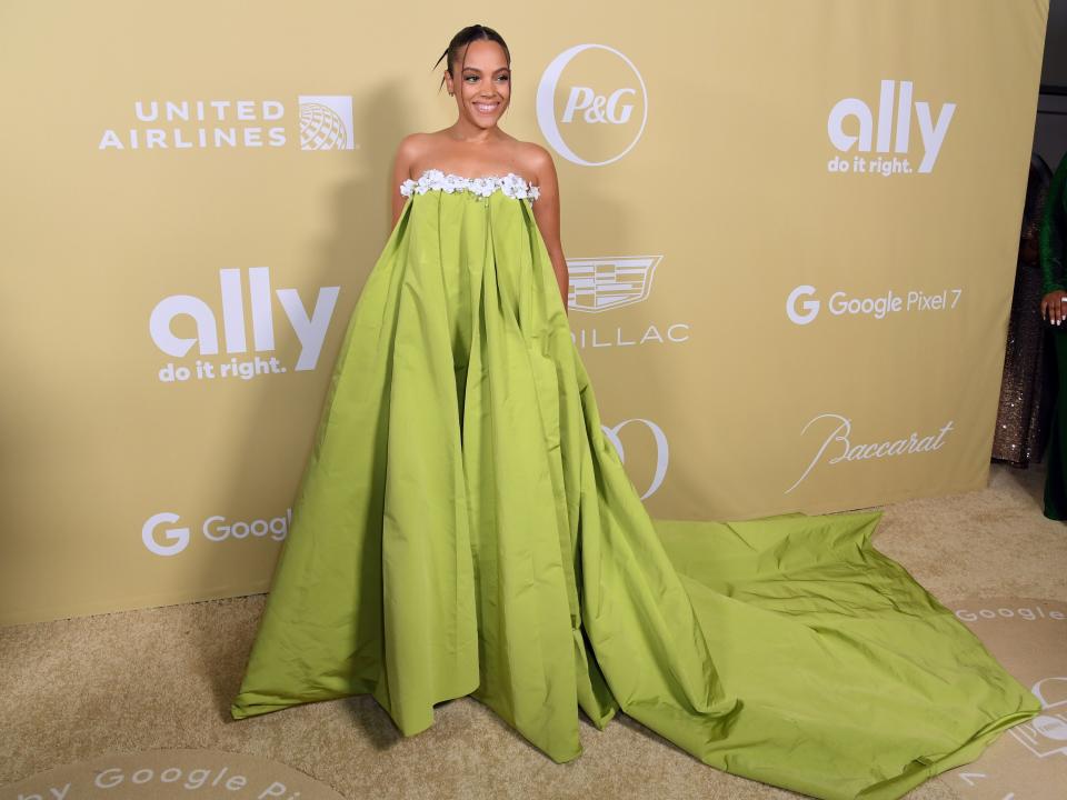 Bianca Lawson in bright green dress in front of beige background