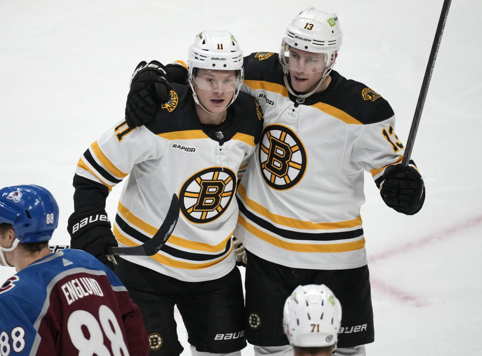 Boston Bruins center Trent Frederic, back left, is congratulated on his goal against the Colorado Avalanche, by center Charlie Coyle during the third period of an NHL hockey game Wednesday, Dec. 7, 2022, in Denver. (AP Photo/David Zalubowski)