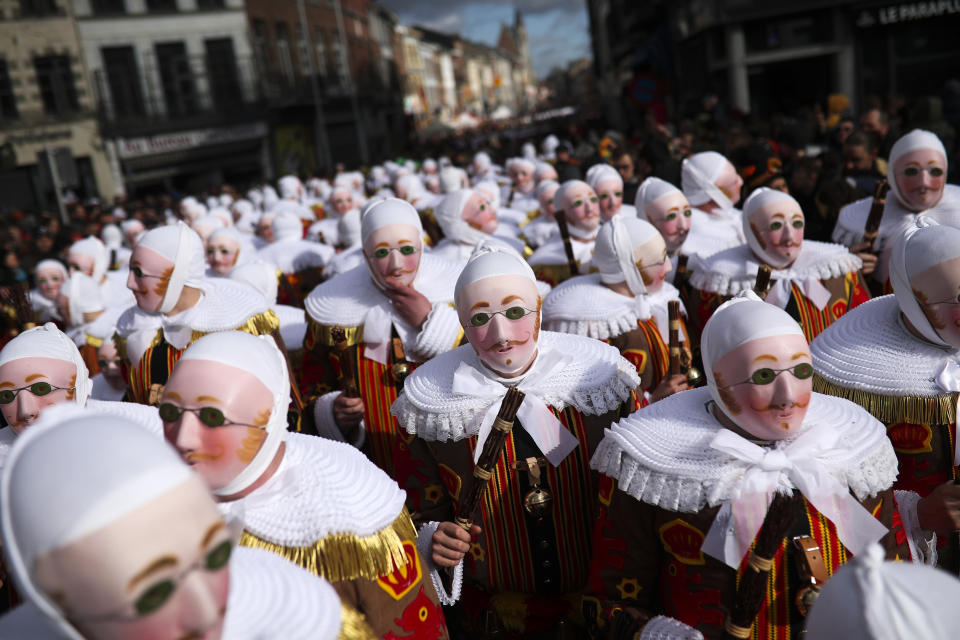 In this Tuesday, Feb. 25, 2020 file photo, a group of people dressed as Gilles de Binche march through the Grand Place during the traditional carnival in Binche, Belgium. The celebration, which heralds the return of spring, is said to date back to 1549 and was put on the UNESCO list in 2003. In normal life, the small town of Binche would be bursting with excitement as craftsmen put the finishing touches to vibrant costumes, but in 2021 the COVID-19 regulations have forced the carnival to be cancelled. (AP Photo/Francisco Seco, File)