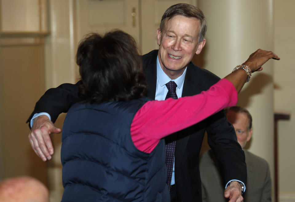 Democratic presidential hopeful John Hickenlooper, back, hugs Colorado state Sen. Rhonda Fields, D-Aurora, during a meeting with survivors of victims of mass shootings in Colorado Tuesday, April 16, 2019, in Denver. Fields lost her son and his fiancee in a shooting in 2005. (AP Photo/David Zalubowski)