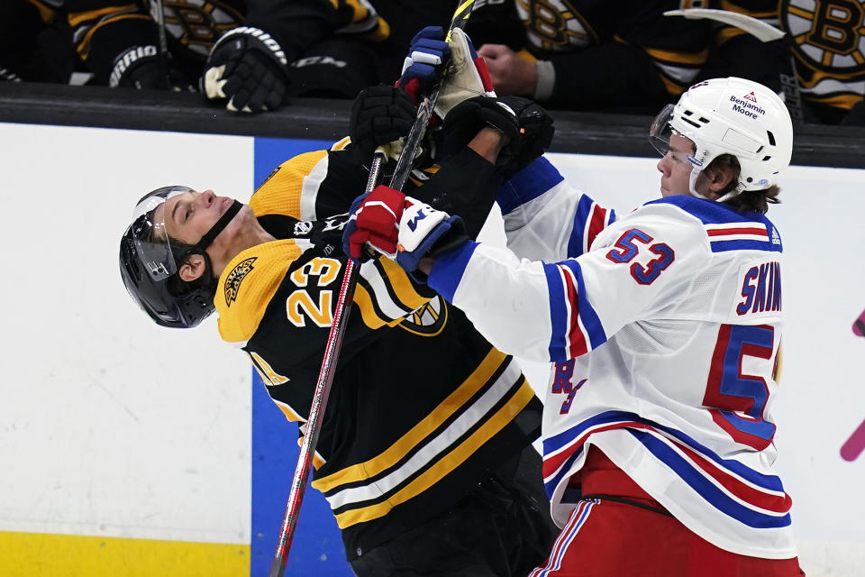 FILE - Boston Bruins center Jack Studnicka (23) snaps backwards on a hard check by New York Rangers defenseman Hunter Skinner (53) during the first period of a preseason NHL hockey game in Boston, Tuesday, Sept. 27, 2022. The New York Rangers have acquired Vladimir Tarasenko and depth defenseman Niko Mikkola from the Blues, in a deal that sent conditional 2023 first- and 2024 fourth-round picks, forward Sammy Blais and prospect Hunter Skinner to St. Louis. (AP Photo/Charles Krupa, File)