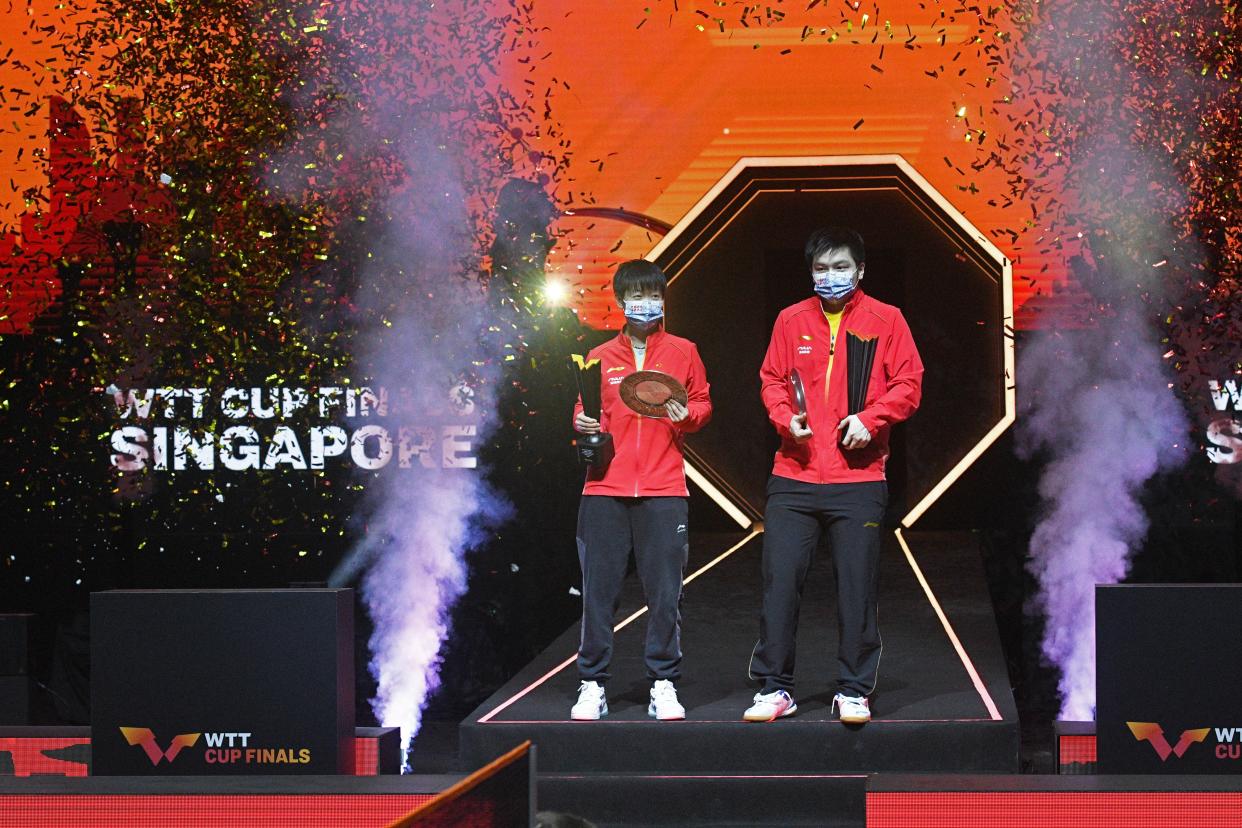 Sun Yingsha (left) and Fan Zhendong with their trophies after winning the women's and men's singles competition respectively at the WTT Cup Finals at the OCBC Arena in Singapore.