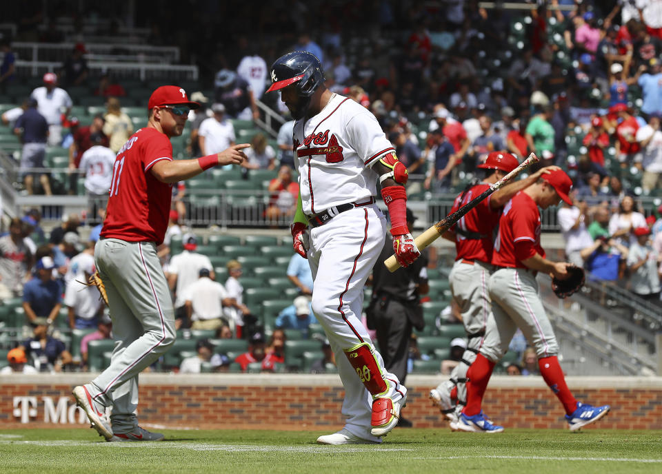 Atlanta Braves designated hitter Marcell Ozuna walks off the field after popping up for the final out of the baseball game to Philadelphia Phillies pitcher David Robertson, right, who celebrates the 3-1 victory with catcher J.T. Realmuto and Rhys Hoskins, left, Wednesday, Aug. 3, 2022, in Atlanta. (Curtis Compton/Atlanta Journal-Constitution via AP)