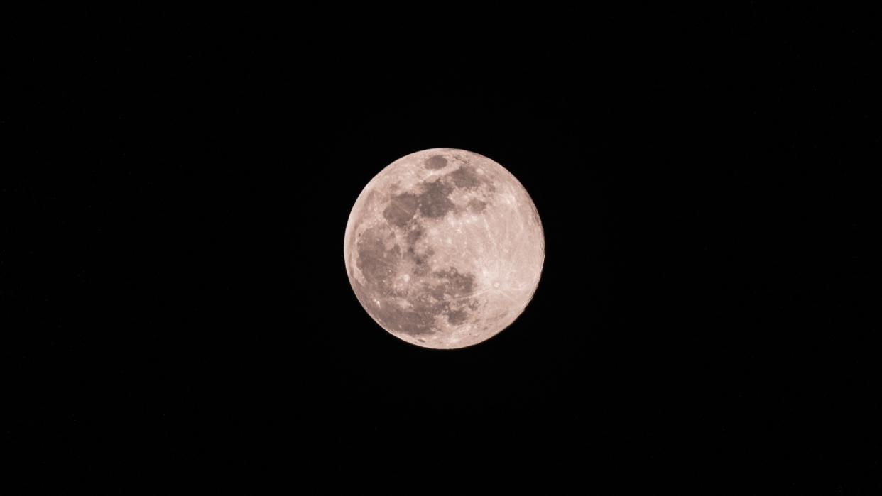  A bright white full moon against a black sky. 