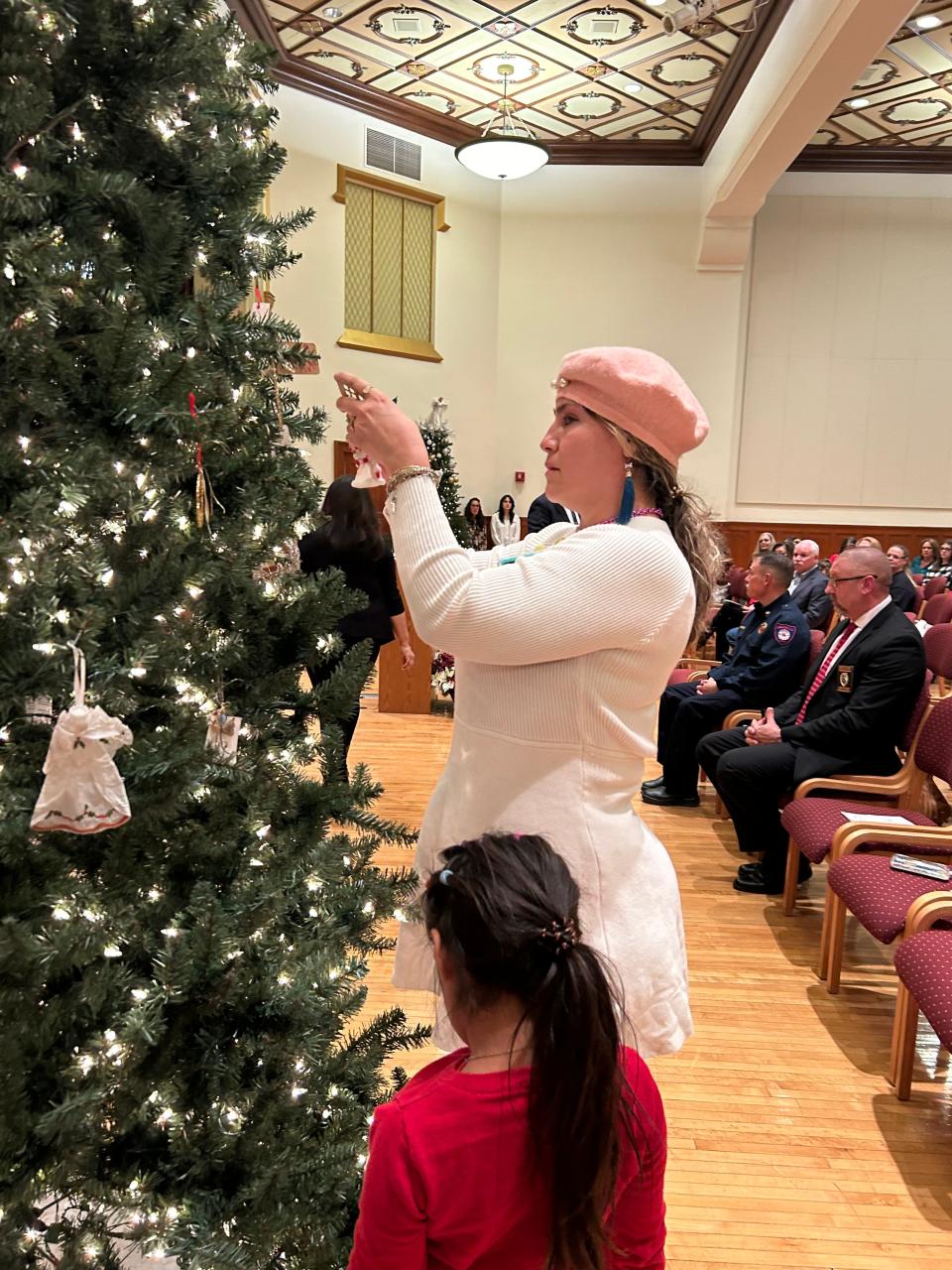 A woman hangs an ornament on the Angel Tree Friday night, to honor a member of her family who died due to a violent crime, during the 21st annual Tree of Angels Ceremony held by the Potter County 47th District Attorney’s Office.