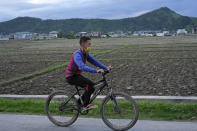 A man wearing a face mask rides a bicycle on a street in Imphal, India, Thursday, June 17, 2021. (AP Photo/Yirmiyan Arthur)