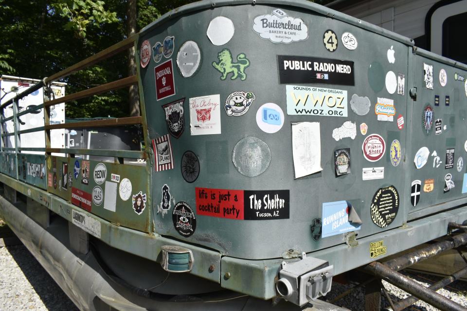 This vintage pontoon boat is personalized with an array of bumper stickers.